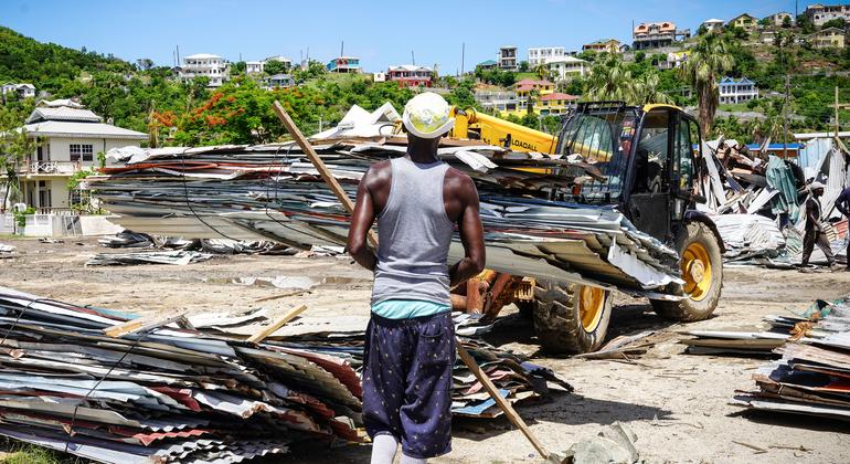 Una excavadora retira los escombros de las casas destruidas en la isla de Unión, tras la devastación causada por el huracán Beryl.