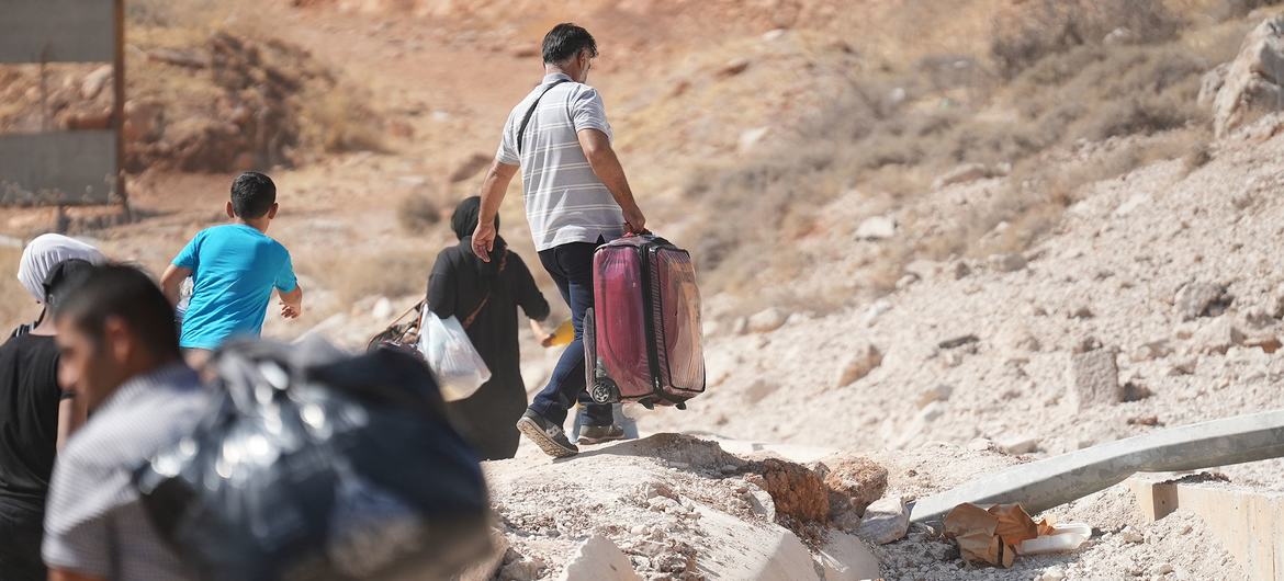 Varias personas que huyen de los ataques aéreos israelíes en Líbano cruzan la frontera de Jdeidet Yabous hacia Siria, el 7 de octubre de 2024.