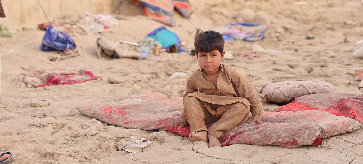 Un niño sentado entre las ruinas de la casa de su familia en la provincia de Baghlan, Afganistán, después de que esta fuera destruida por una inundación repentina en mayo de 2024.