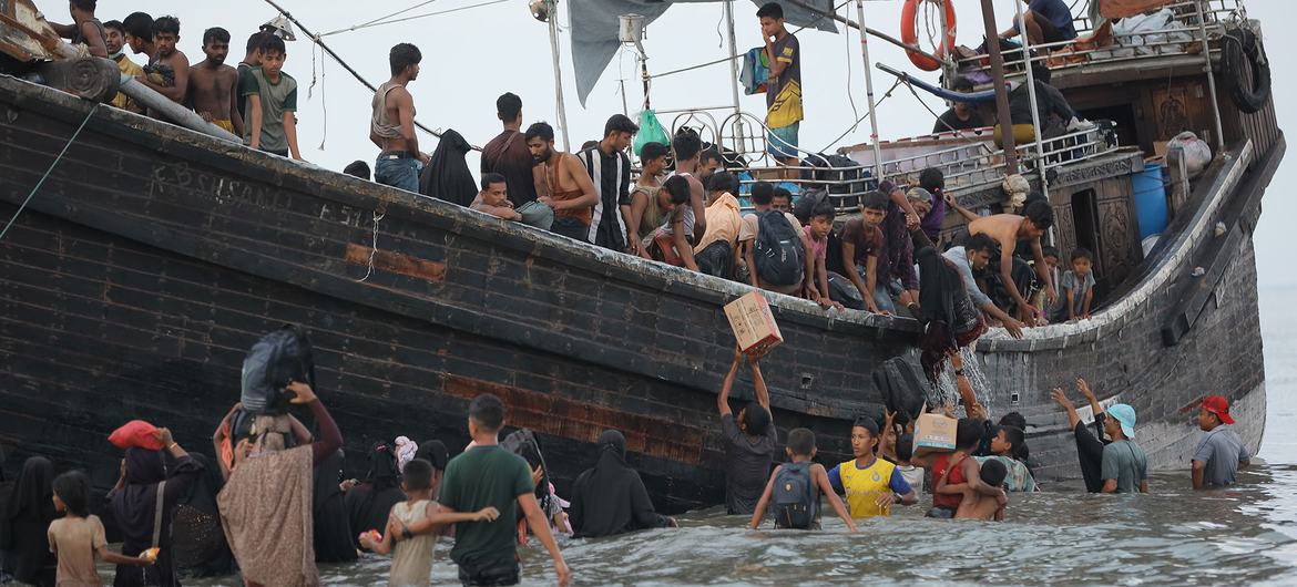 Personas refugiadas rohingyas que llegan a Ulee Madon, en Aceh del Norte, Indonesia, procedentes de Bangladesh, descargan sus pertenencias.