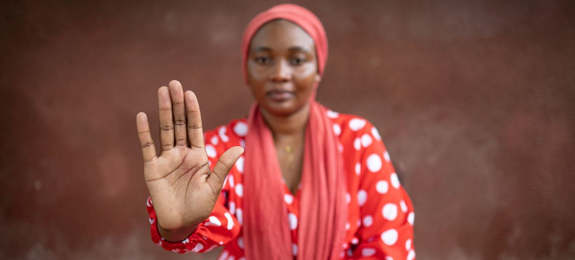 Josefina Cheia, Oficial de Violencia de Género de ACNUR en Mozambique, hace un gesto con la mano que significa “alto a la violencia contra las mujeres y las niñas”.